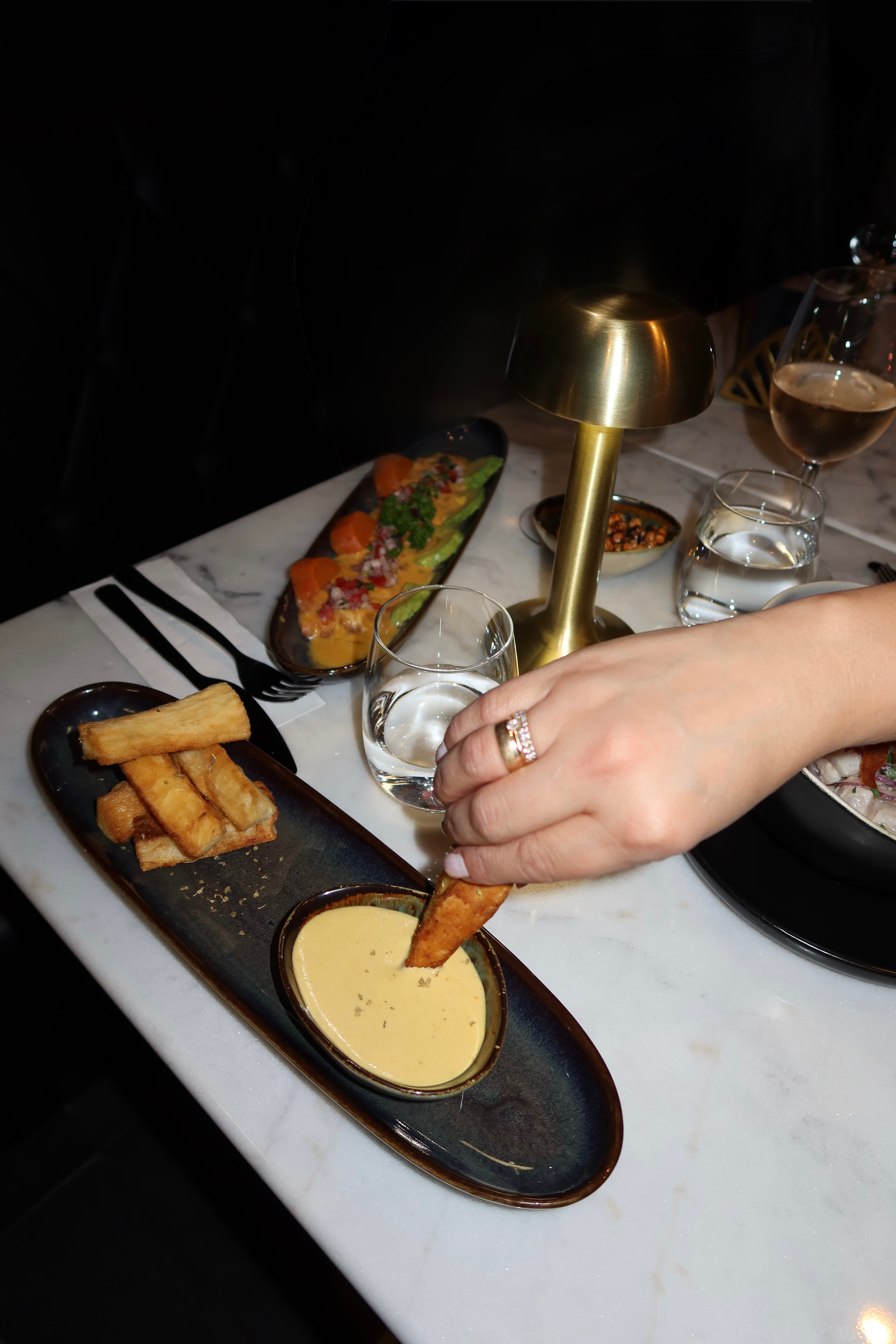 Yuca frites et sauce à partager sur une table en marbre