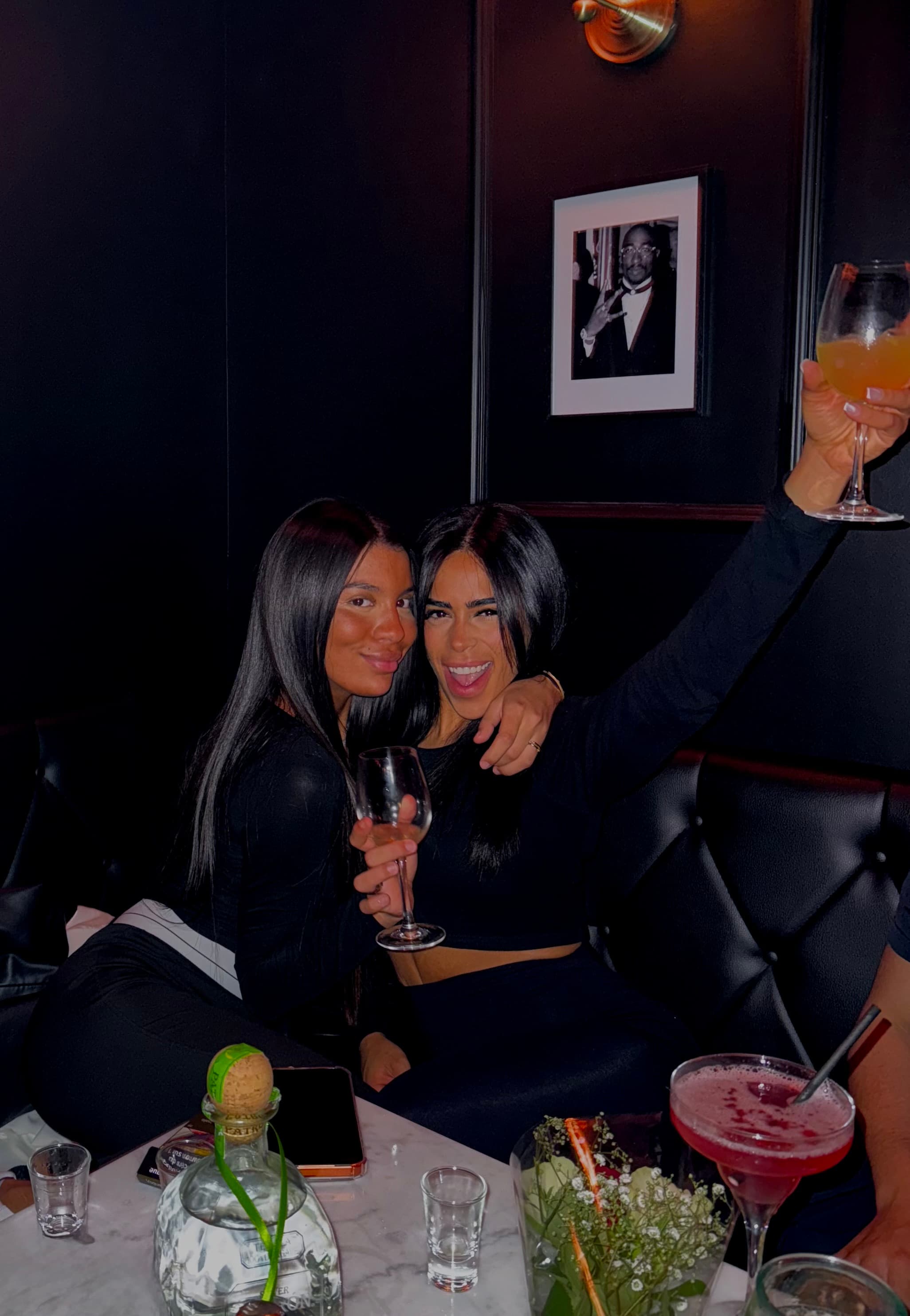 Clients trinquant avec des cocktails dans l'ambiance tamisée du bar