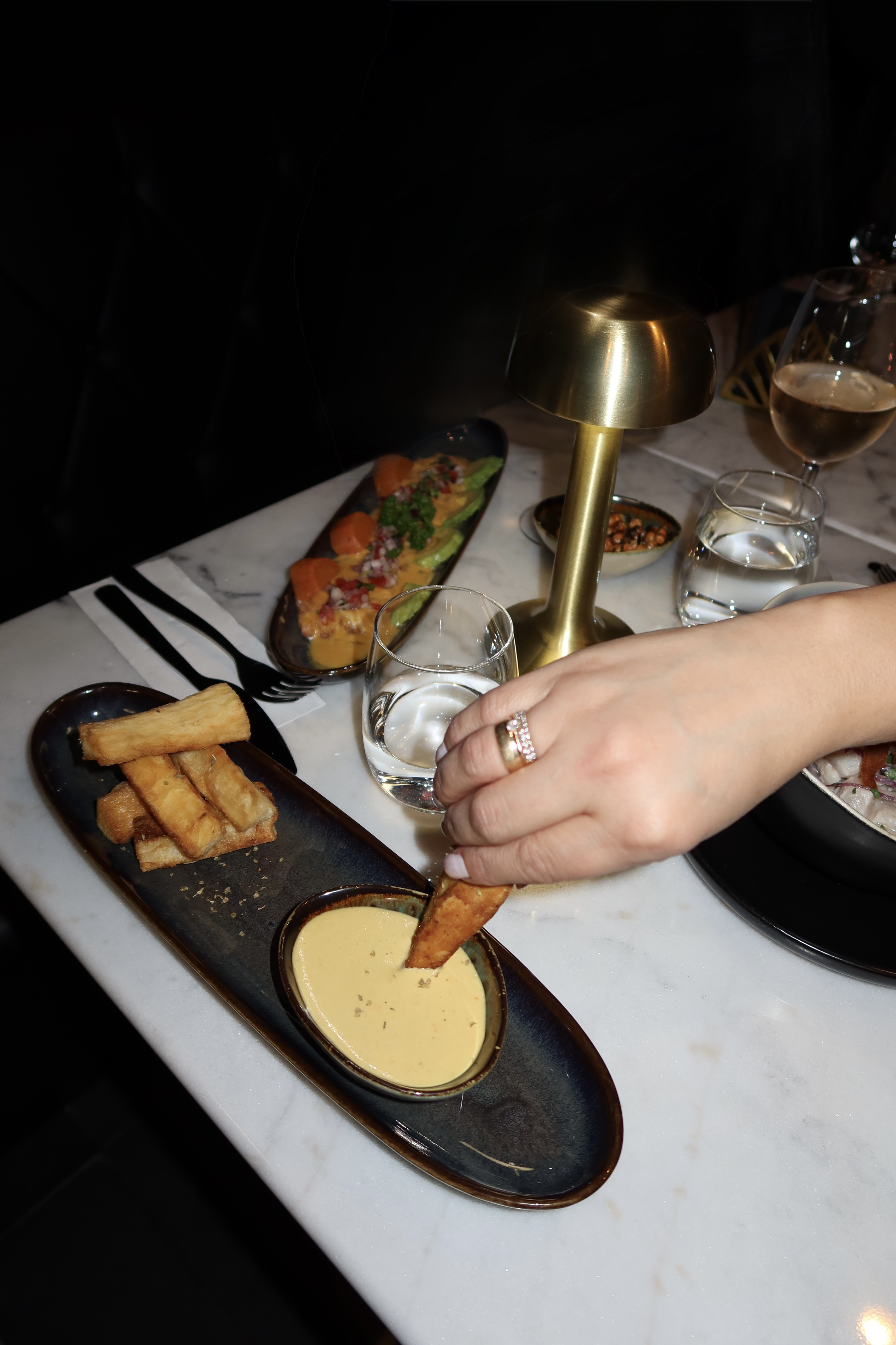 Yuca fries and dipping sauce to share on a marble table
