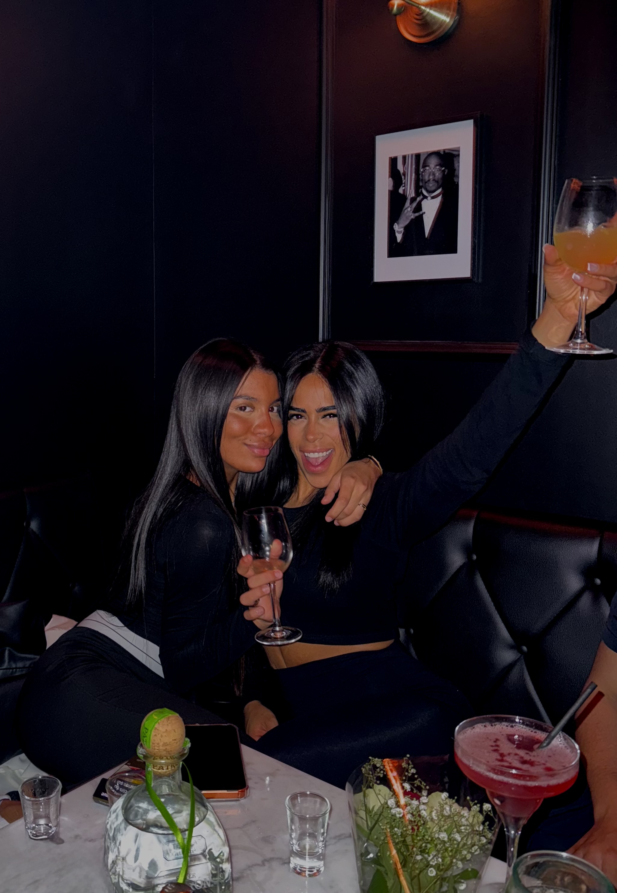 Guests toasting cocktails in the dimly lit bar interior